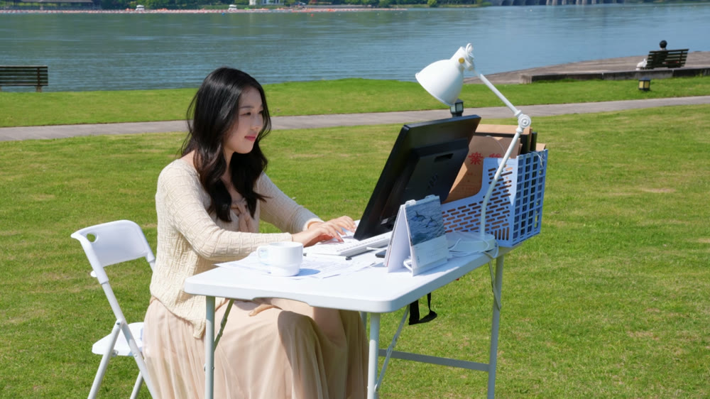 暂用同项目画面：人物在湖边草坪工作
